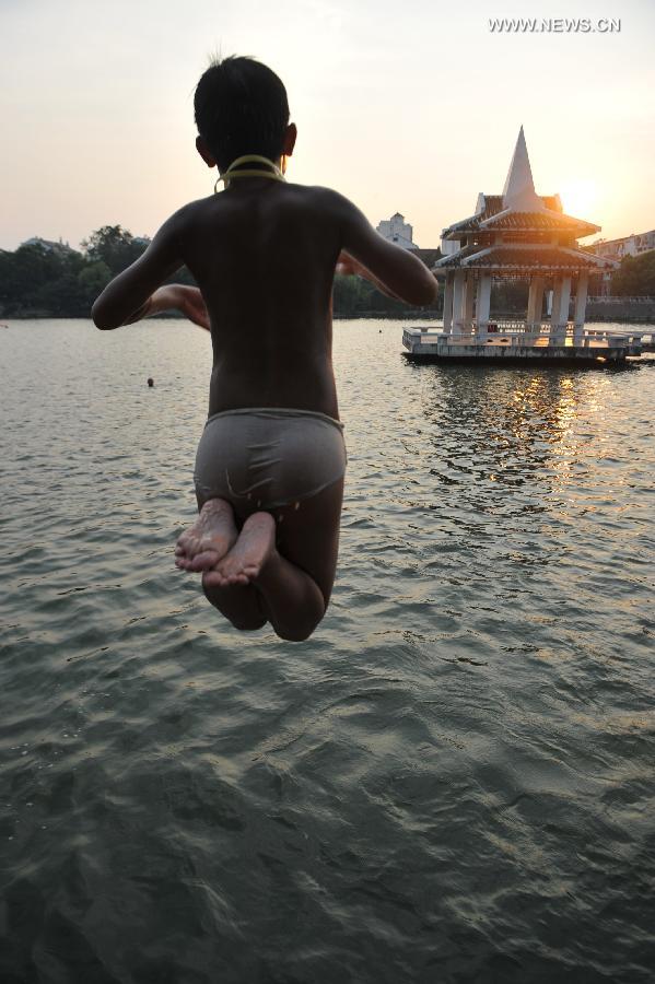 A boy jumps to the lake to cool himself off at the Huancheng Park in Hefei, capital of east China's Anhui Province, July 24, 2013. (Xinhua/Yang Xiaoyuan)