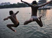 Boys jump to lake to cool off in E China 