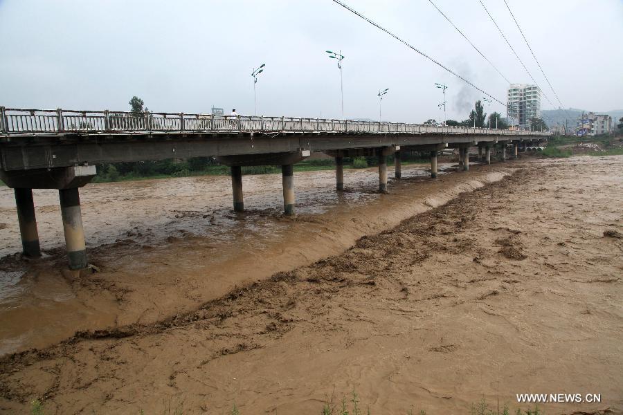 Water level of the Dong River rises due to continuous torrential rain, in Chengxian County of Longnan City, northwest China's Gansu Province, July 25, 2013. A torrential rain battered Chengxian County Wednesday night, causing landslips, collapses and traffic disrupted. A total of 1,060 residents have been evacuated by now. (Xinhua/Liu Min) 