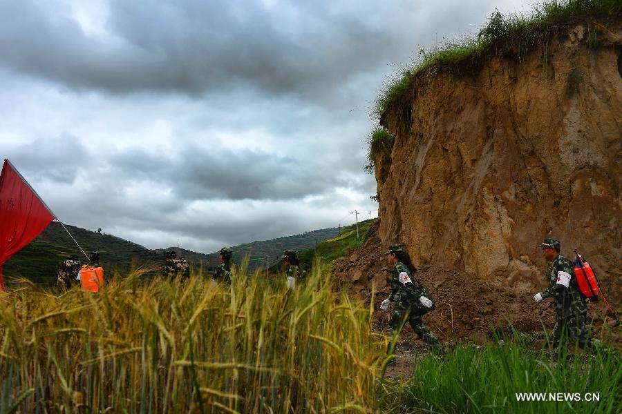 Photo taken on July 25, 2013 shows a medical team heading for mountain area in Meichuan Township of quake-hit Minxian County, northwest China's Gansu Province. Precautions have been taken to prevent second disasters since a torrential rainfall started on Wednesday in the quake-stricken area. (Xinhua/Jin Liangkuai)