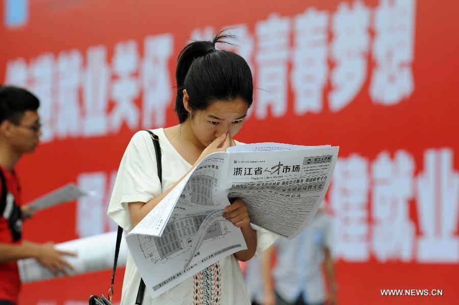 Photo taken on June 8, 2013 shows a job seeker reading job information in Hangzhou, capital of east China's Zhejiang Province. Figures from the Ministry of Human Resources and Social Security on July 25 showed that the urban employment increased by 7.25 million in China in the first six months of the year, an increase of 310,000 year on year. The registered urban unemployment rate stood at 4.1 percent at the end of the second quarter. (Xinhua/Ju Huanzong)