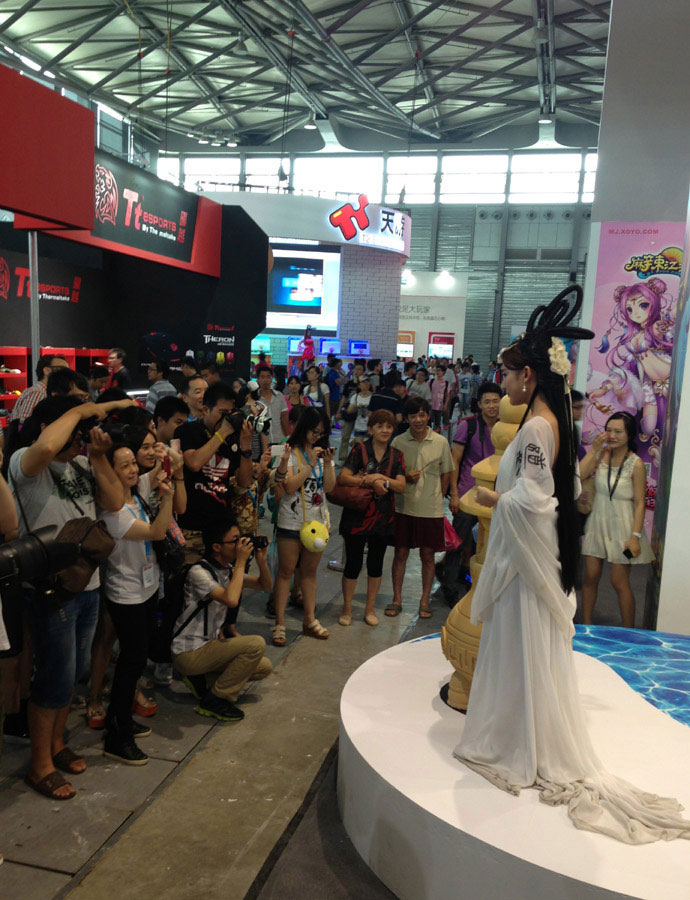 Visitors watch a show at the 11th ChinaJoy, the China Digital Entertainment Expo and Conference on July 25, 2013.(Shi Jing/ chinadaily.com.cn)