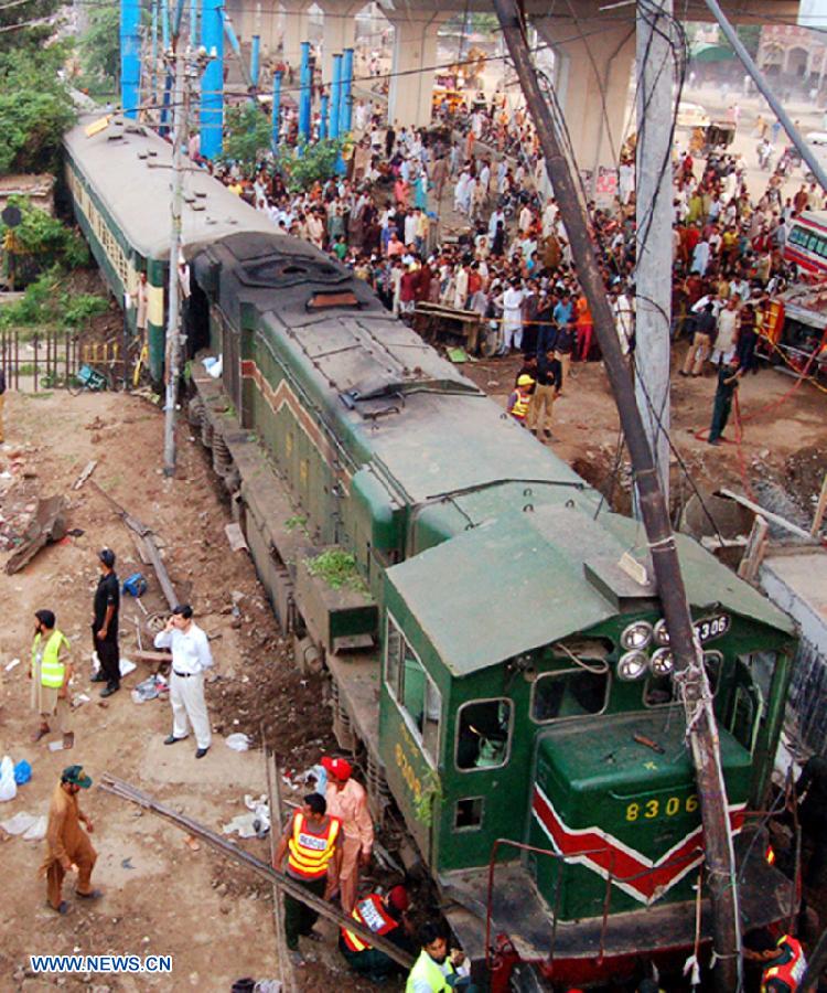 People gathered at a derailed train in eastern Pakistan's Gujranwala on July 25, 2013. At least three people were killed and several others injured when a train derailed here on Thursday, local media reported. (Xinhua/Stringer) 