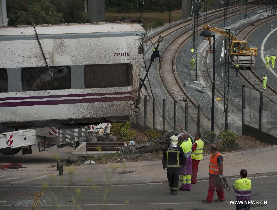 Rescuers work at the accident site at the entrance of Santiago de Compostela Station, in the autonomous community of Galicia, northwest of Spain, on July 25, 2013. The death toll has risen to at least 80 after a train derailed outside the city of Santiago de Compostela on late July 24, according to the police. (Xinhua/Xie Haining)