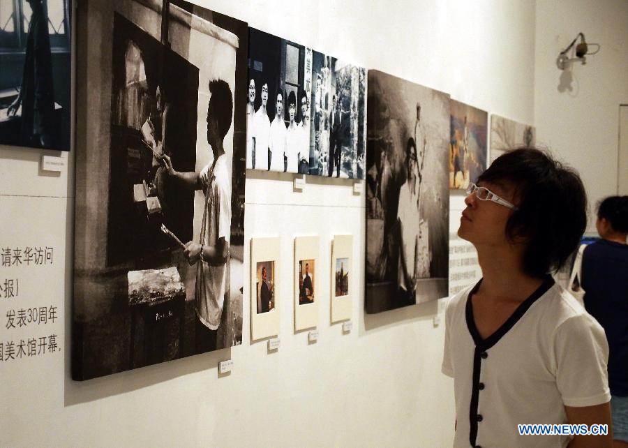 A visitor views items about late Chinese painter Chen Yifei during an exhibition in Shanghai Oil Painting and Sculpture Institute, east China's Shanghai, July 25, 2013. An exhibition about the life and the works of Chen Yifei, one of China's most acclaimed painters and visual artists who died in 2005, is opened in the institute on Thursday. (Xinhua/Ren Long)