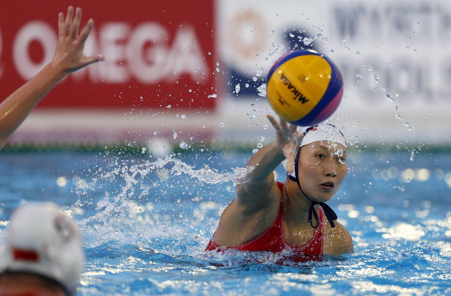 China's Xu Lu (R) passes the ball during the women's water polo group B preliminary round match between China and New Zealand in the 15th FINA World Championships in Barcelona, Spain, on July 25, 2013. China won 13-5. (Xinhua/Wang Lili)
