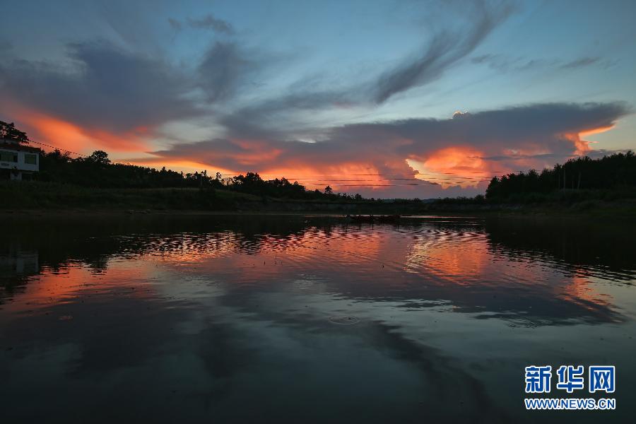 July 23, amazing sunset glow reflect in the pond. The provincial meteorological observatory issued an orange alert for high temperatures in Hunan, estimating that the highest temperature will be above 37 degrees Celsius in most parts of the province. (Photo/Xinhua)