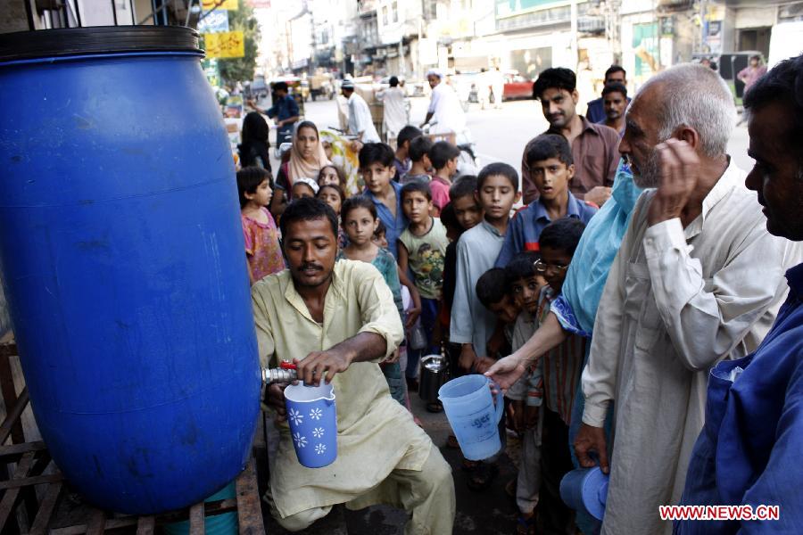 A man distributes milk to poor people during holy month of Ramadan in eastern Pakistan's Lahore on July 26, 2013. Muslims around the world refrain from eating, drinking and smoking from dawn to dusk during the fasting month of Ramadan. (Xinhua/Jamil Ahmed)