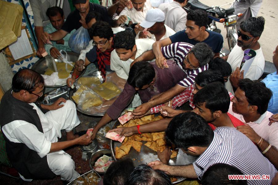 Pakistani people buy food before breaking their fast during the holy month of Ramadan in eastern Pakistan's Lahore on July 26, 2013. Muslims around the world refrain from eating, drinking and smoking from dawn to dusk during the fasting month of Ramadan. (Xinhua/Jamil Ahmed)