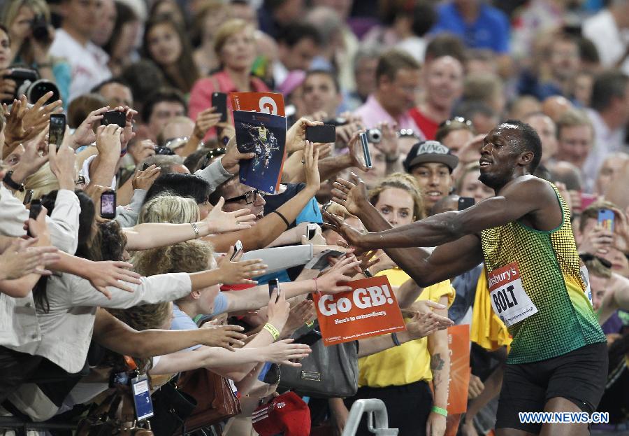 Usain Bolt (1st R) of Jamaica celebrates with spectators after winning the men's 100m race at the London Diamond League 'Anniversary Games' athletics meeting at the Olympic Stadium in London, Britain, on July 26, 2013. Bolt claimed the title with 9.85 seconds. (Xinhua/Yin Gang)