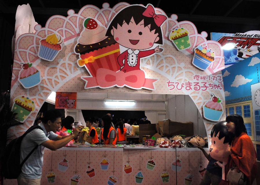 A visitors poses for a photo at the pavilion of Japanese animation "Chibi Maruko" at the Animation, Comics & Games Expo in Hong Kong (ACGHK), south China, July 26, 2013. The five-day ACGHK, starting here Friday, is expected to attract some 700,000 visitors. (Xinhua/Zhao Yusi) 