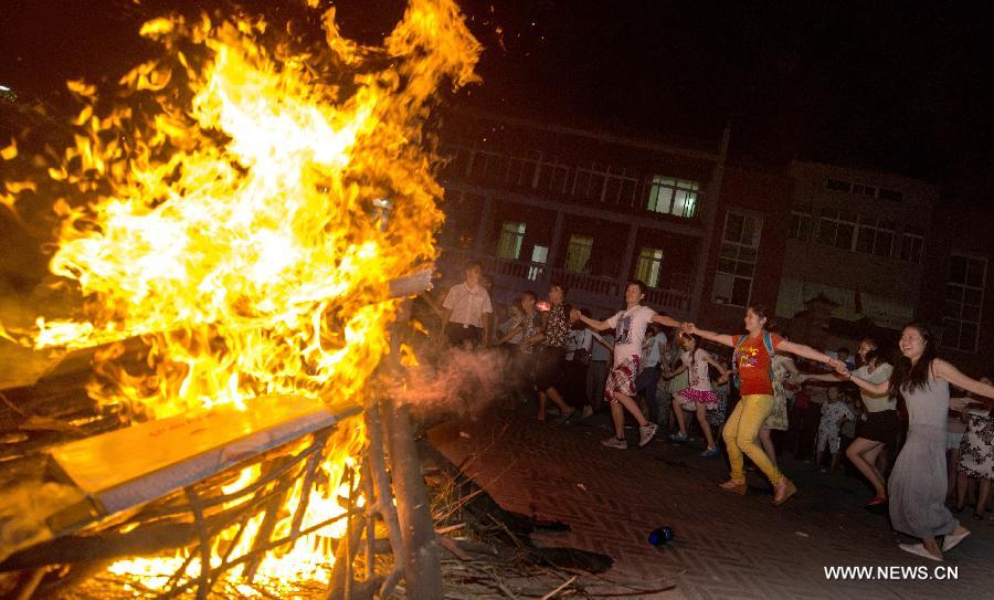 Tourists take part in a campfire party at Guifeng Mountain in Macheng City, central China's Hubei Province, July 27, 2013. A lot of citizens chose to escape the heat in the mountains due to the continuous scorching weather in Hubei province in recent days. (Xinhua/Cheng Min)