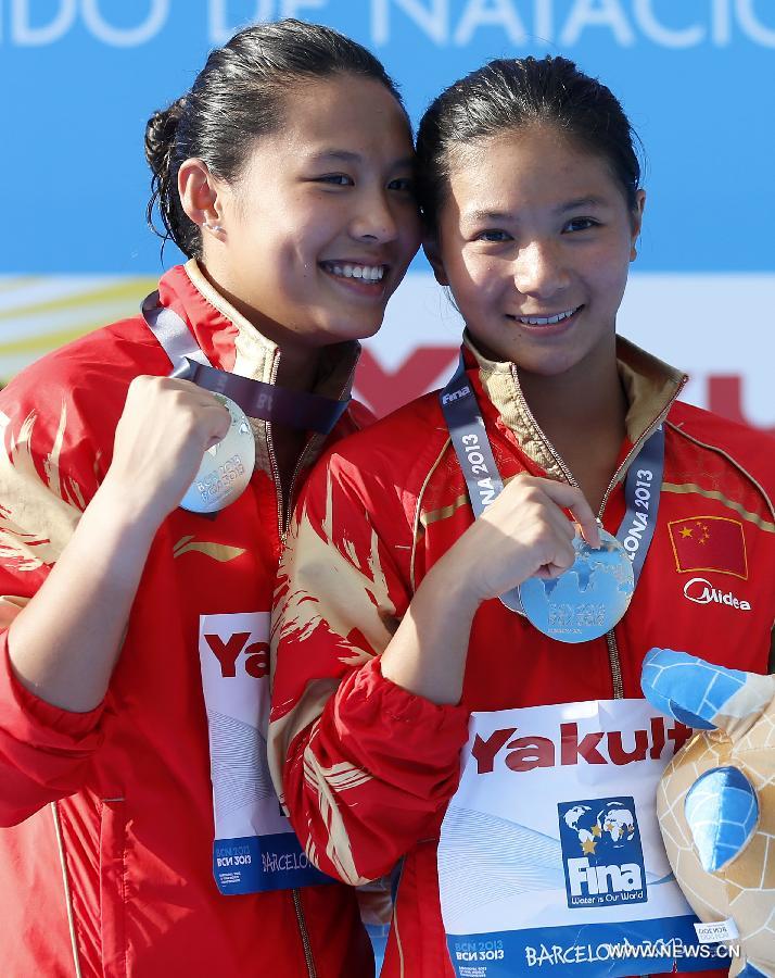 China's He Zi (R) and Wang Han react during the awarding ceremony for Women's 3m Springboard diving at the 15th FINA World Championships in Barcelona, Spain, on July 27, 2013. He Zi claimed the title with a total score of 383.40 points while Wang Han took the silver medal. (Xinhua/Wang Lili) 