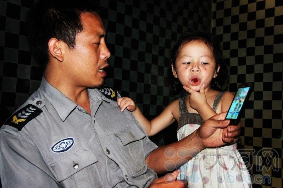 Zhang shows the photos in the mobile phone to Yimin. When Zhang was asked why he chose Yimin instead of his girl friend, he said: "I met the child by destination. I decided to adopt her and I couldn't abandon her for any reason." (Photo/Dahe.cn)  