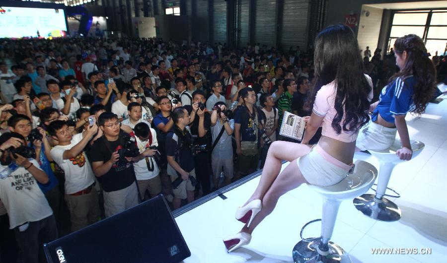 Models present a game product at the 11th China International Digital Entertainment Expo (China Joy 2013) in Shanghai, east China, July 28, 2013. The expo kicked off on Thursday, with over 300 related enterprises participating. (Xinhua/Pei Xin)