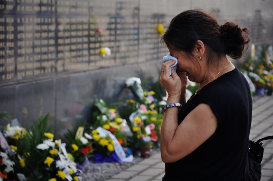 A woman mourns for her relatives died in the 1976 Tangshan earthquake in front of the memorial wall in Tangshan, north China's Hebei Province, July 28, 2013. Local residents came to the memorial park on Sunday to commemorate the 37th anniversary of the Tangshan earthquake. (Photo/Xinhua)
