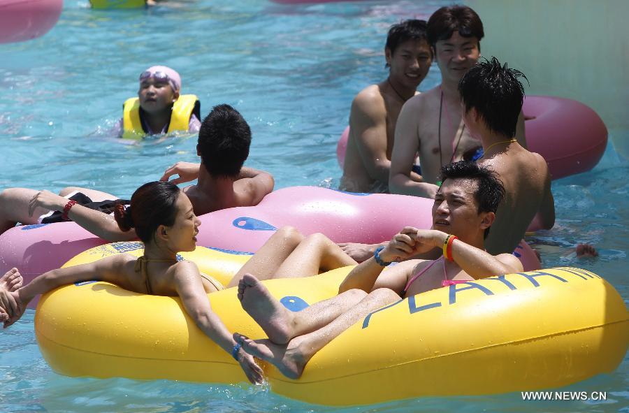 Tourists cool off in a water park in Shanghai on July 28, 2013. The highest temperature reached 39 degrees Celsius in Shanghai on Sunday. (Xinhua/Ding Ting)