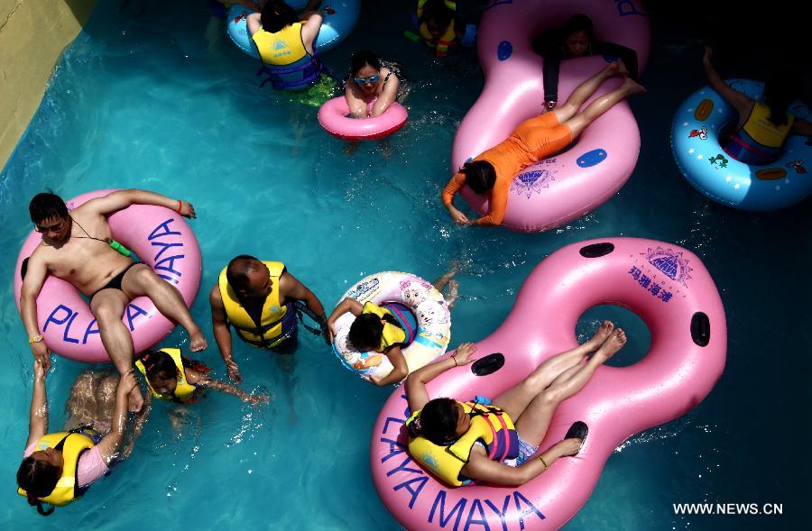 Tourists cool off in a water park in Shanghai on July 28, 2013. The highest temperature reached 39 degrees Celsius in Shanghai on Sunday. (Xinhua/Ding Ting)
