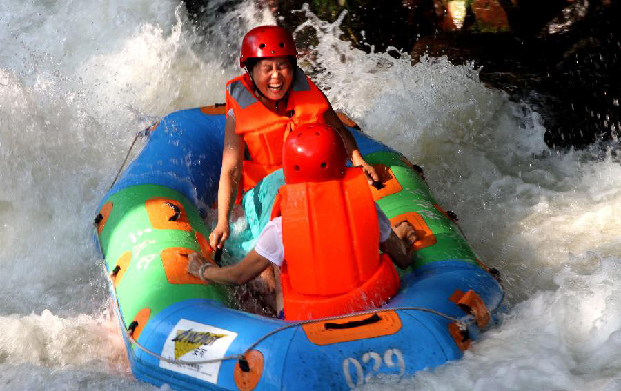 Tourists raft on the water at a forest park in Jing'an County, east China's Jiangxi Province, July 28, 2013. A heat wave hit many parts of the country these days. (Xinhua/Xu Zhongting)