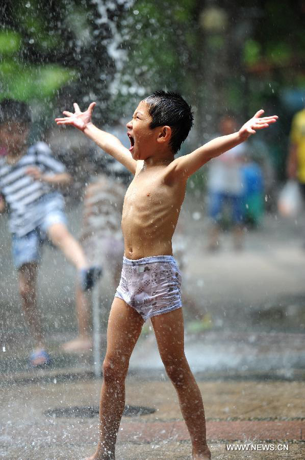 A boy cools off himself in a fountain in Hangzhou, capital of east China's Zhejiang Province, July 28, 2013. Hangzhou has experienced the temperature of over 40 degrees Celsius since July 24. (Xinhua/Xu Hui)
