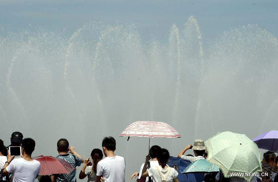Citizens cool off themselves near a musical fountain in Hangzhou, capital of east China's Zhejiang Province, July 28, 2013. Hangzhou has experienced the temperature of over 40 degrees Celsius since July 24. (Xinhua/Shi Jianxue)