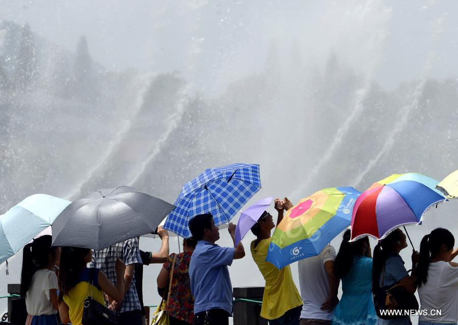 Citizens cool off themselves near a musical fountain in Hangzhou, capital of east China's Zhejiang Province, July 28, 2013. Hangzhou has experienced the temperature of over 40 degrees Celsius since July 24. (Xinhua/Shi Jianxue)