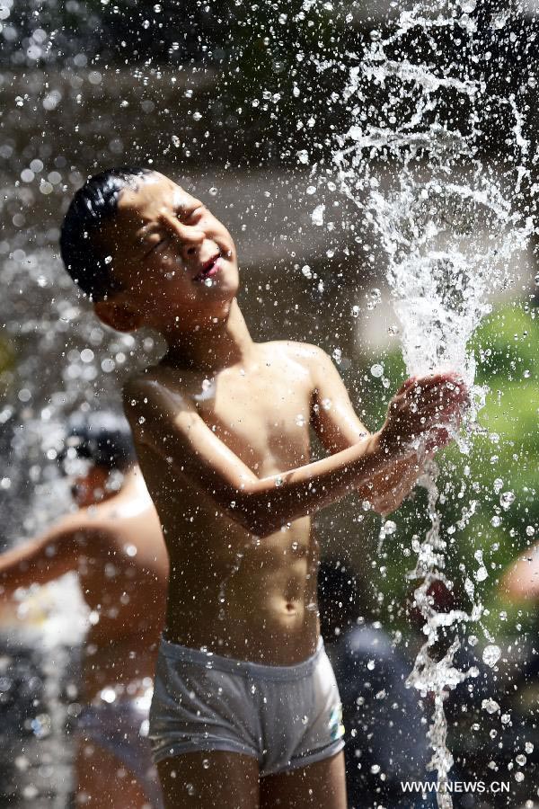 A boy cools off himself in a fountain in Hangzhou, capital of east China's Zhejiang Province, July 28, 2013. Hangzhou has experienced the temperature of over 40 degrees Celsius since July 24. (Xinhua/Li Zhong)