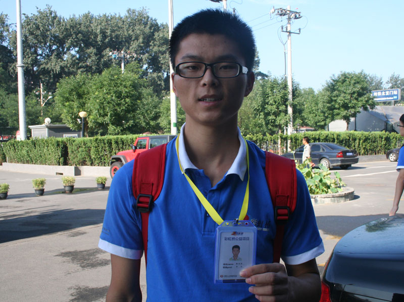 A Chinese student, Han Xingwei, who comes from a poor mountain village in China, happily shows his "identity card" produced by the organizer of the 2013"Rainbow Bridge" charity program on Wednesday morning, July 24, 2013. [Photo: CRIENGLISH.com]