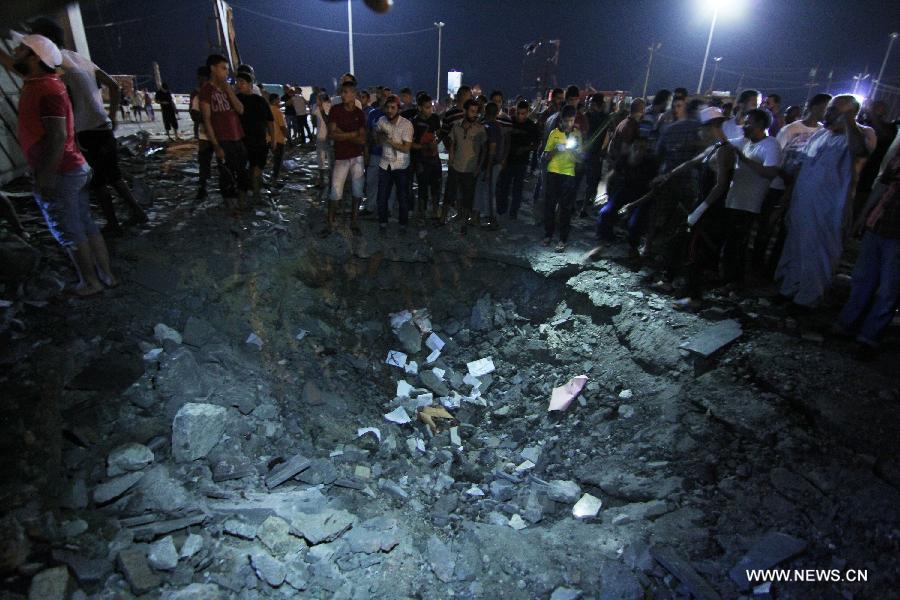 People gather at an explosion site in Benghazi, Libya, July 28, 2013. Two courthouses in Libya's eastern city of Benghazi were hit by explosions on Sunday night, leaving 13 people injured and causing property damage, security sources told Xinhua. (Xinhua)