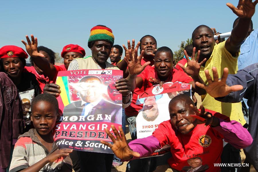 People gather at a campaign rally of presidential election candidate Morgan Tsvangirai in Chitungwiza of Harare, capital of Zimbabwe, July 28, 2013. Zimbabweans are expected to vote on July 31 to choose a president, legislators, and local councilors. Incumbent President Robert Mugabe and Prime Minister Morgan Tsvangirai are considered the main contenders for the presidency. (Xinhua/Meng Chenguang) 