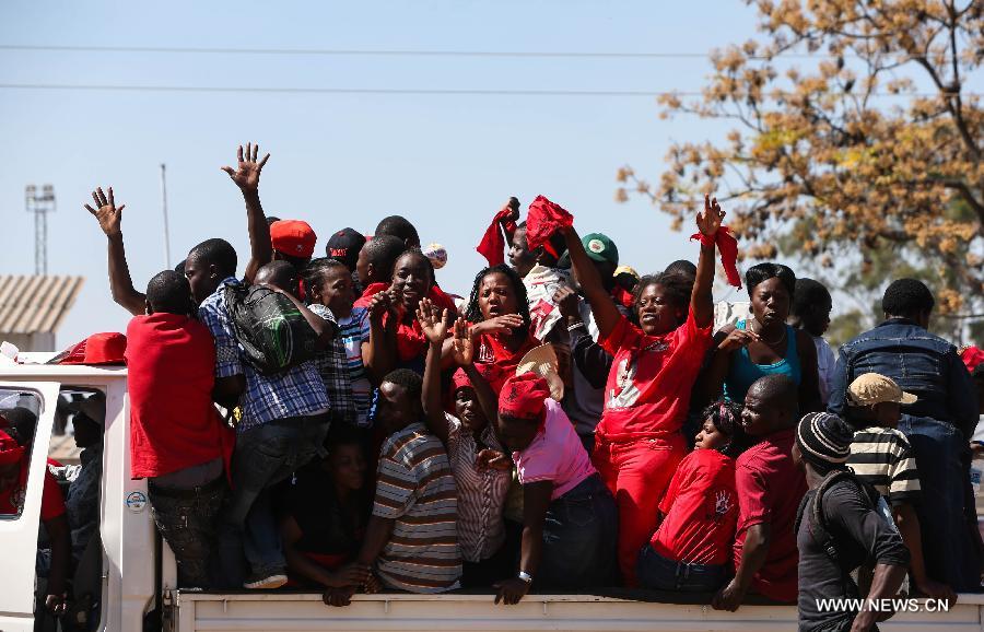 Supporters stand on a truck during a campaign rally of presidential election candidate Morgan Tsvangirai in Chitungwiza of Harare, capital of Zimbabwe, July 28, 2013. Zimbabweans are expected to vote on July 31 to choose a president, legislators, and local councilors. Incumbent President Robert Mugabe and Prime Minister Morgan Tsvangirai are considered the main contenders for the presidency. (Xinhua/Meng Chenguang) 