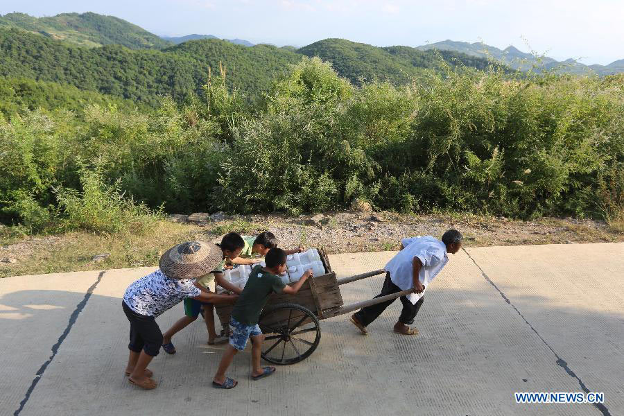 Villagers convey drinking water at Qishi Village in Loudi City, central China's Hunan Province, July 27, 2013. A drought that has already lasted several weeks is continuing to linger in Hunan, leaving 533,000 people short of drinking water. (Xinhua/Guo Guoquan)