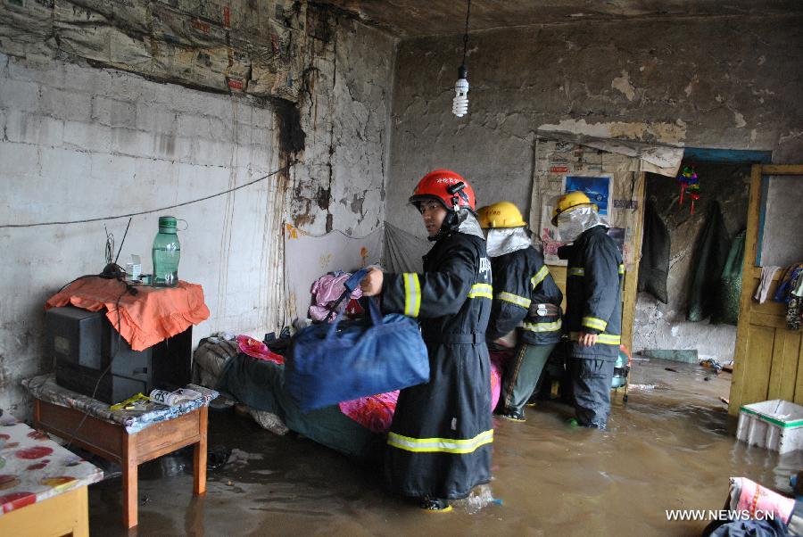 Rescuers help transfer belongings of residents in flood-hit Genhe City, Hulun Buir, north China's Inner Mongolia Autonomous Region, July 28, 2013. Rainstorm-triggered flood hit the city on Sunday. (Xinhua/Feng Changcai) 