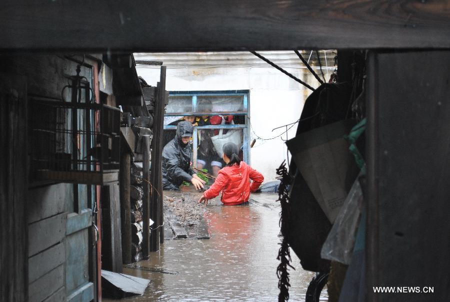 Residents are trapped in a flooded house in Genhe City, Hulun Buir, north China's Inner Mongolia Autonomous Region, July 28, 2013. Rainstorm-triggered flood hit the city on Sunday. (Xinhua/Feng Changcai)