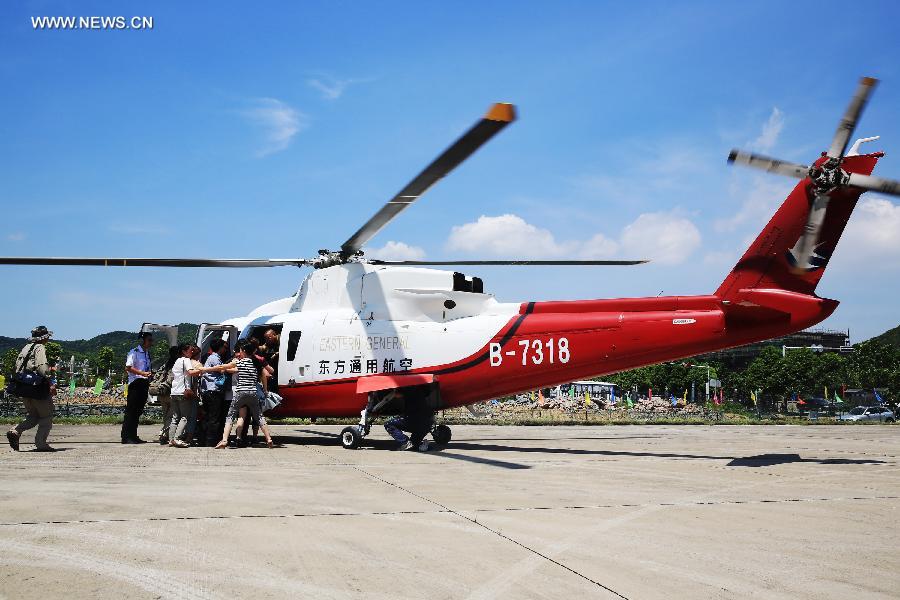 Journalists and tourists prepare to board a helicopter for sightseeing in Lushan Mountain of Jiujiang City, east China's Jiangxi Province, July 28, 2013. Helicopters are to be used for sightseeing in the famous scenery area on Sunday. (Xinhua/Zhang Haiyan)