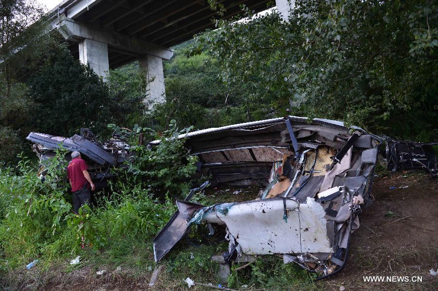 Photo taken on July 29, 2013 shows the wrecked tourist bus in Avellino, southern Italy. A tourist bus crashed through a highway guardrail in southern Italy Sunday night, killing 38 people and putting at least 10 others in critical condition. (Xinhua/Xu Nizhi) 