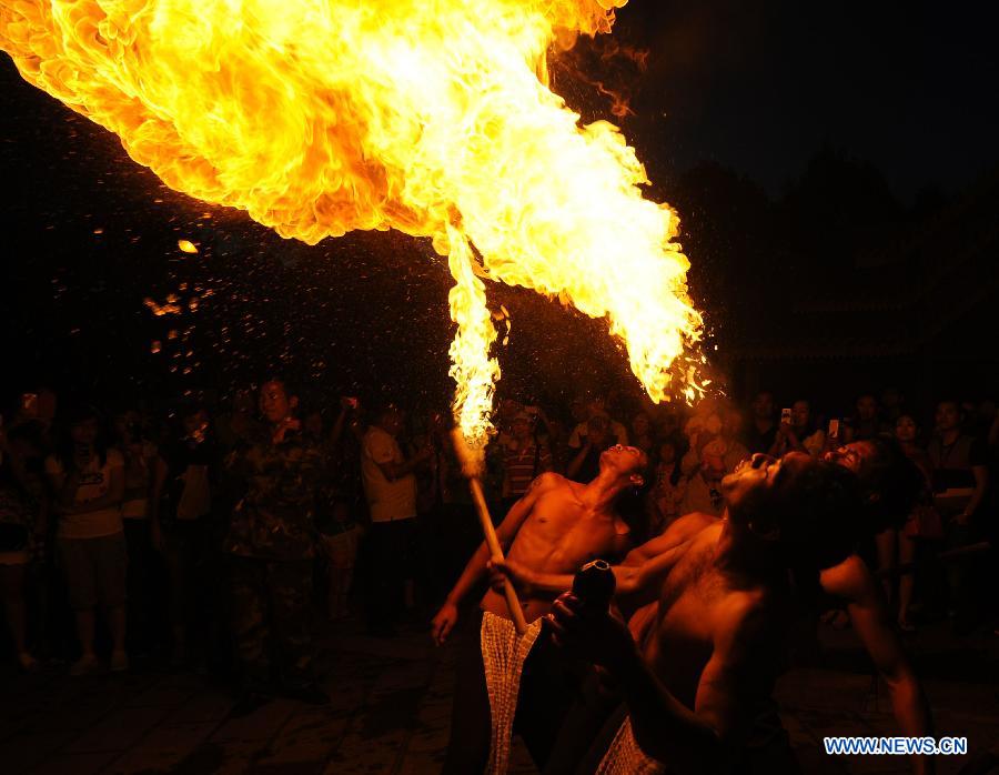 Young men of the Yi ethnic group perform during a parade to celebrate the Torch Festival at Yunnan Nationalities Village in Kunming City, southwest China's Yunnan Province, July 28, 2013. The Torch Festival, which falls around the 24th day of the sixth Chinese lunar month every year, is the traditional holiday of the Yi ethnic group and some other ethnic groups. (Xinhua/Qin Lang)