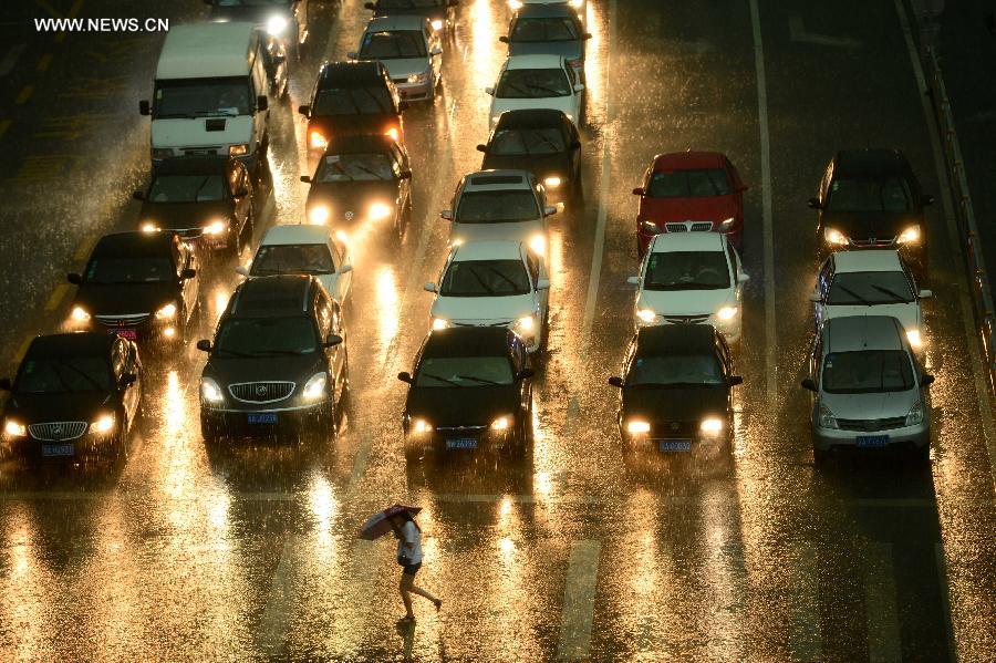 Vehicles move in torrential rain in a street in Jinan, capital of east China's Shandong Province, July 29, 2013. A sudden downpour hit the city on Monday afternoon. (Xinhua/Guo Xulei) 