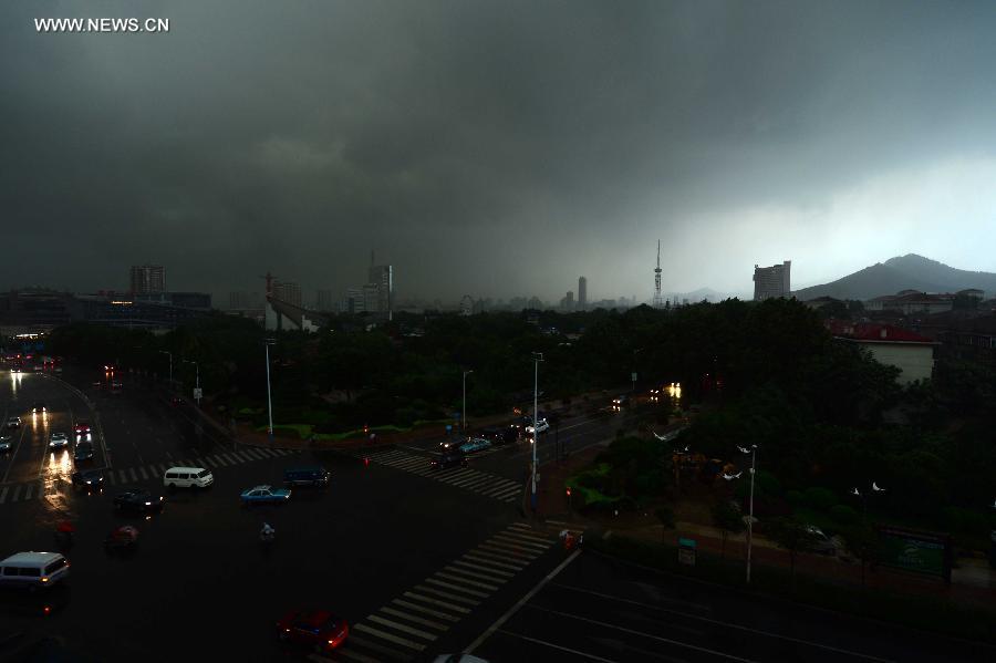 Buildings are shrouded by dark clouds in Jinan, capital of east China's Shandong Province, July 29, 2013. A sudden downpour hit the city on Monday afternoon. (Xinhua/Guo Xulei)