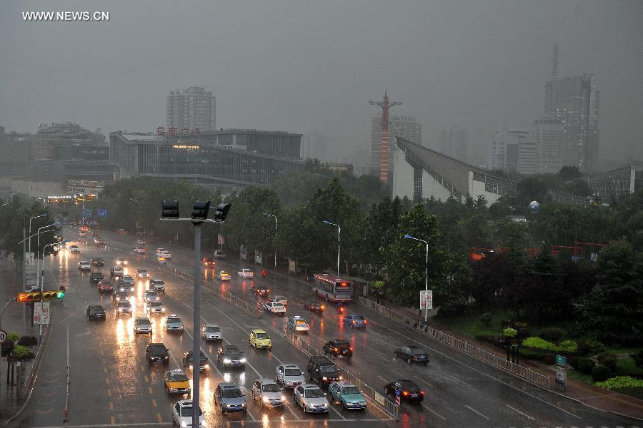 Vehicles travel in torrential rain in a street in Jinan, capital of east China's Shandong Province, July 29, 2013. A sudden downpour hit the city on Monday afternoon. (Xinhua/Zhu Zheng)