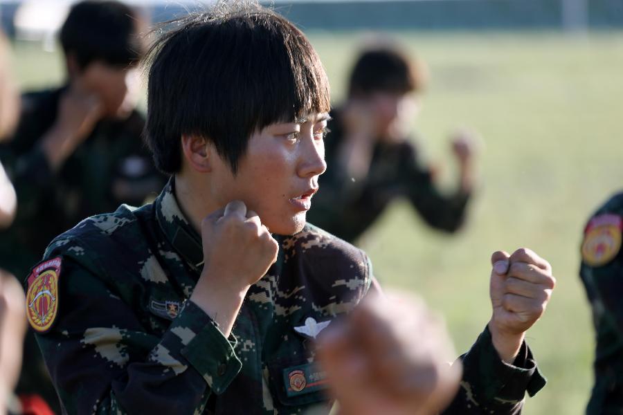 Female soldier Liu Xueying is seen during the hand-to-hand combat training at the Zhurihe training base in north China's Inner Mongolia Autonomous Region, July 16, 2013. The first female special forces unit established by the Chinese People's Liberation Army received intensive training as the Army Day is coming. The youngest soldier of the unit is 18 years old while the oldest one is 26. All of the female soldiers have college degrees or above and have been trained to master special combat skills. (Xinhua/Wang Jianmin)