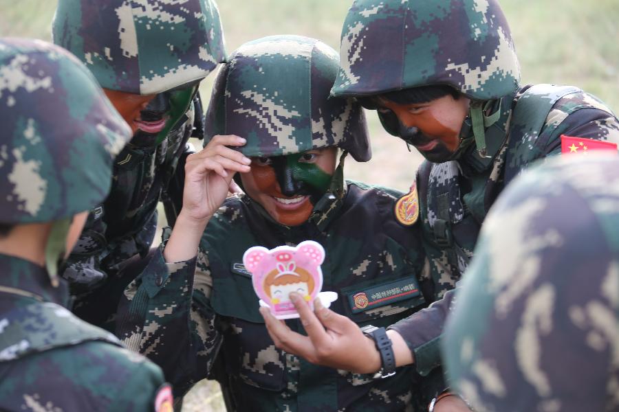 Female soldiers check their camouflage paintings at the Zhurihe training base in north China's Inner Mongolia Autonomous Region, July 17, 2013. The first female special forces unit established by the Chinese People's Liberation Army received intensive training as the Army Day is coming. The youngest soldier of the unit is 18 years old while the oldest one is 26. All of the female soldiers have college degrees or above and have been trained to master special combat skills. (Xinhua/Wang Jianmin)