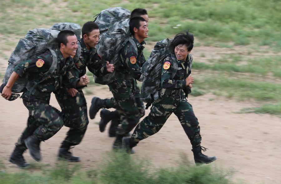 Female soldier Peng Shuang (R) runs with male soldiers in a five-kilometer-cross-country training at the Zhurihe training base in north China's Inner Mongolia Autonomous Region, July 18, 2013. The first female special forces unit established by the Chinese People's Liberation Army received intensive training as the Army Day is coming. The youngest soldier of the unit is 18 years old while the oldest one is 26. All of the female soldiers have college degrees or above and have been trained to master special combat skills. (Xinhua/Wang Jianmin)