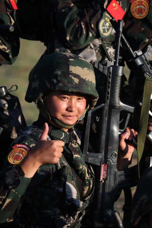 Female soldier Li Jin poses for photo during a training break at the Zhurihe training base in north China's Inner Mongolia Autonomous Region, July 16, 2013. The first female special forces unit established by the Chinese People's Liberation Army received intensive training as the Army Day is coming. The youngest soldier of the unit is 18 years old while the oldest one is 26. All of the female soldiers have college degrees or above and have been trained to master special combat skills. (Xinhua/Wang Jianmin)