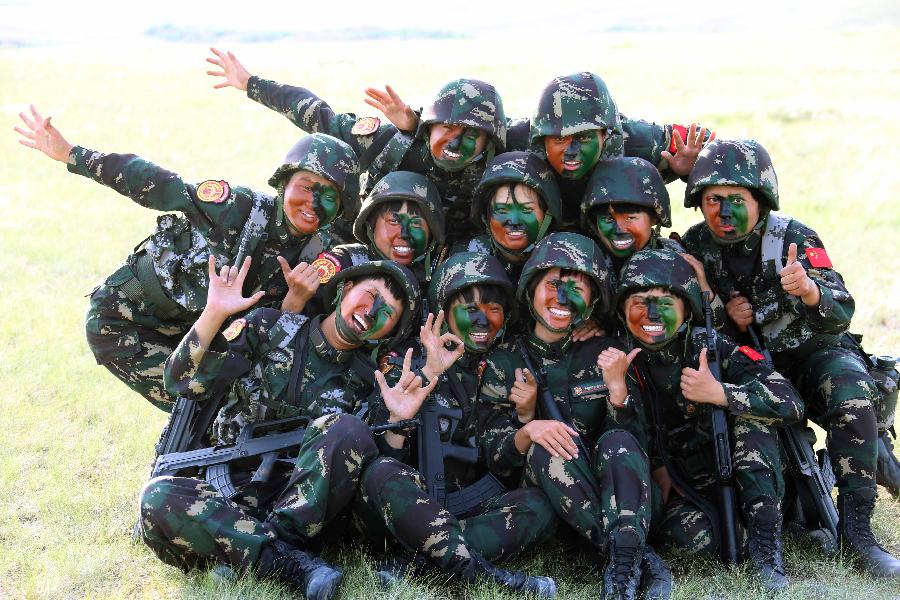 Female soldiers pose for photo during a training break at the Zhurihe training base in north China's Inner Mongolia Autonomous Region, July 17, 2013. The first female special forces unit established by the Chinese People's Liberation Army received intensive training as the Army Day is coming. The youngest soldier of the unit is 18 years old while the oldest one is 26. All of the female soldiers have college degrees or above and have been trained to master special combat skills. (Xinhua/Wang Jianmin)