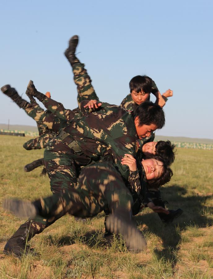 Female soldiers practice hand-to-hand combat at the Zhurihe training base in north China's Inner Mongolia Autonomous Region, July 16, 2013. The first female special forces unit established by the Chinese People's Liberation Army received intensive training as the Army Day is coming. The youngest soldier of the unit is 18 years old while the oldest one is 26. All of the female soldiers have college degrees or above and have been trained to master special combat skills. (Xinhua/Wang Jianmin)