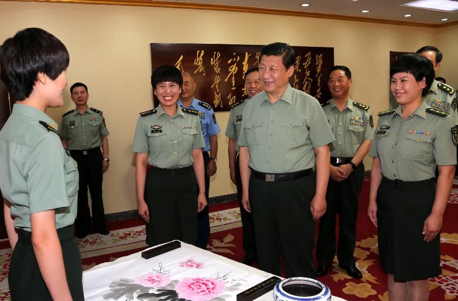 Chinese President Xi Jinping (C), also general secretary of the Central Committee of the Communist Party of China (CPC) and chairman of the Central Military Commission (CMC), talks with a soldier during his tour of the Beijing Military Area Command in Beijing, capital of China, July 29, 2013. Xi made this visit ahead of the Army Day, which falls on Aug. 1 and marks the 86th anniversary of the founding of the People's Liberation Army (PLA). (Xinhua/Li Gang)