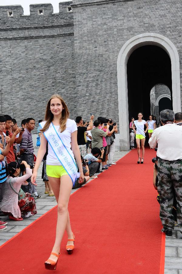 Contestants of the 23rd World Model Organization (WMO) world super model contest finals attend a themed photography activity at the Dongjiang shore in north China's Tianjin Municipality, July 28, 2013. In total 37 super models from more than 20 countries and regions all over the world will compete during the final of the 23rd WMO super model contest on Aug. 2, 2013 in Tianjin. (Xinhua/Xue Liqiang)