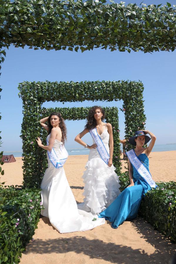 Contestants of the 23rd World Model Organization (WMO) world super model contest finals pose for pictures during a themed photography activity at the Dongjiang shore in north China's Tianjin Municipality, July 28, 2013. In total 37 super models from more than 20 countries and regions all over the world will compete during the final of the 23rd WMO super model contest on Aug. 2, 2013 in Tianjin. (Xinhua/Xue Liqiang)