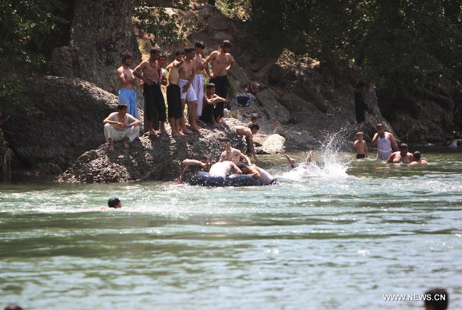 Afghans cool themselves in a canal in Parwan province of Afghanistan on July 29, 2013. (Xinhua/Ahmad Massoud)
